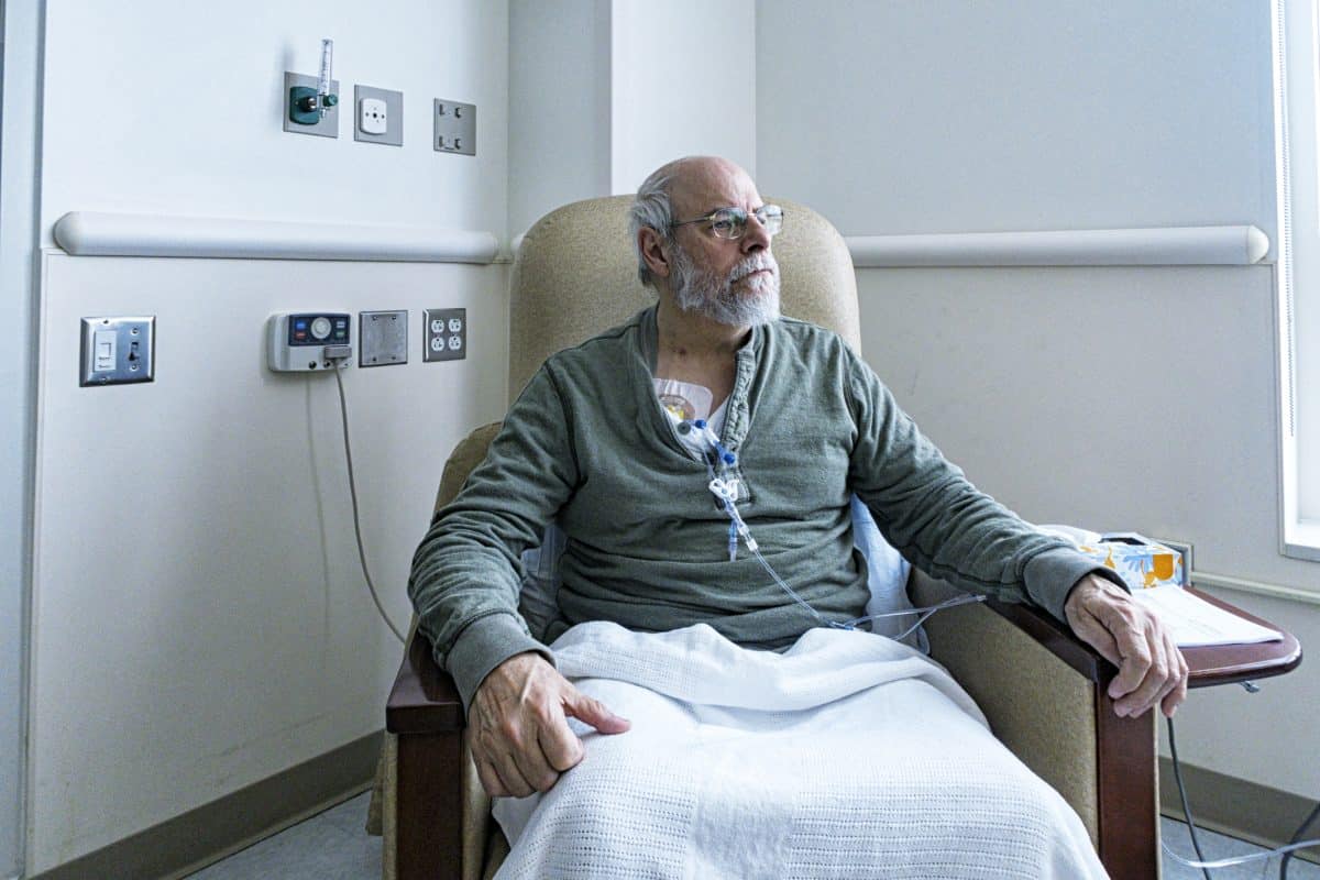 A elderly man sits in a chair without receiving medical attention after an operation at an Alabama hospital.