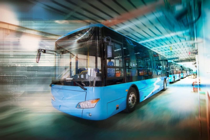 Blurred image of blue passenger buses in a line.