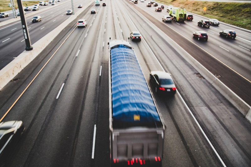 Cars and a semi-truck driving on the highway.