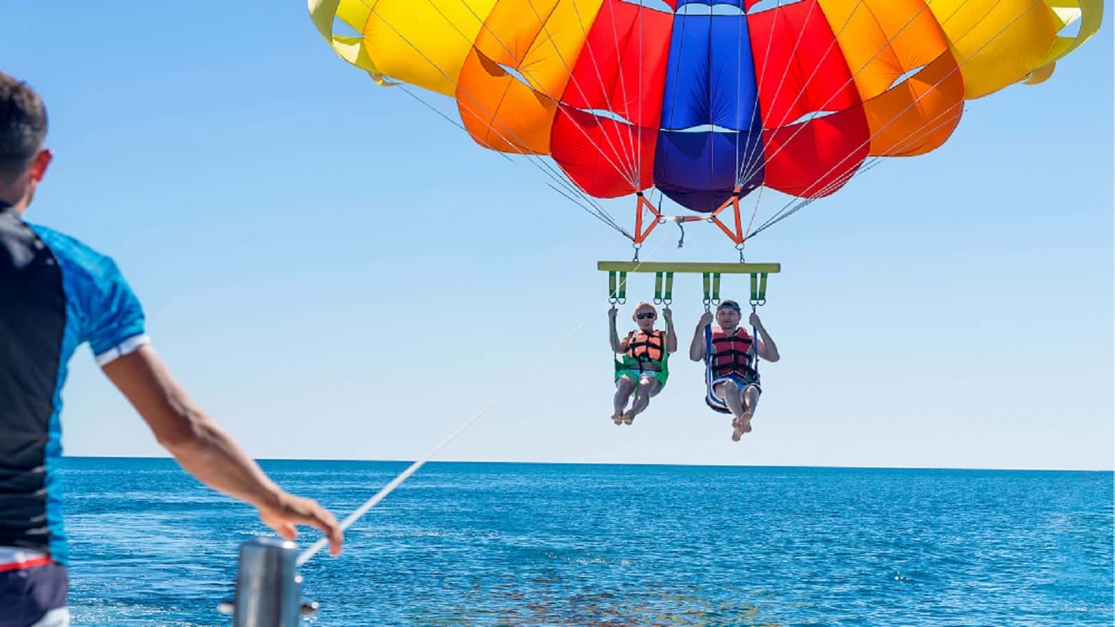Happy Couple Parasailing On The Ocean Stock Photo