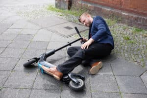man on ground after becoming injured on scooter