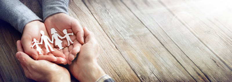 Family Caring For Family - Hands With Paper Silhouette On Table