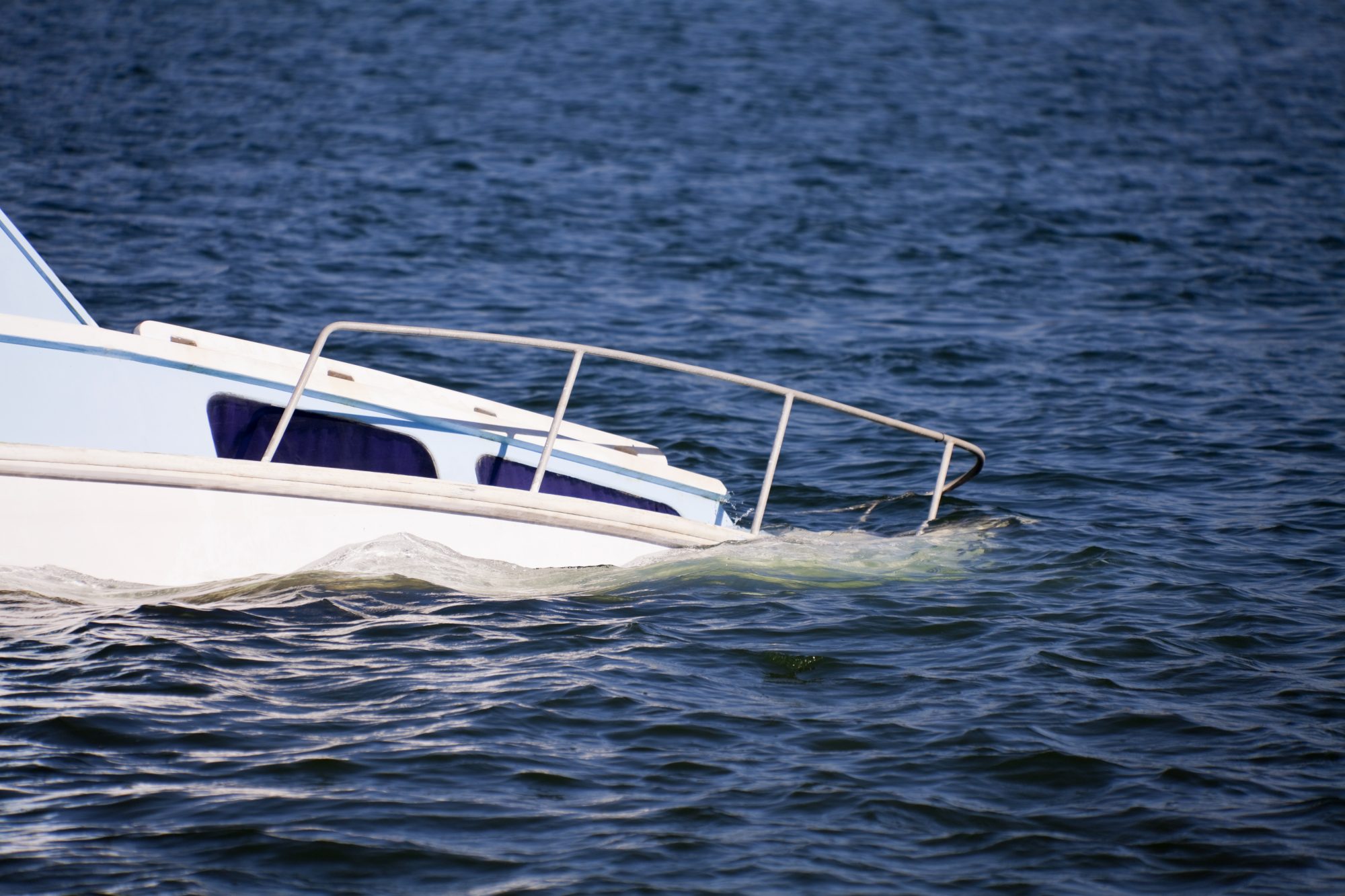 A boat is almost entirely submerged after an accident on the water.