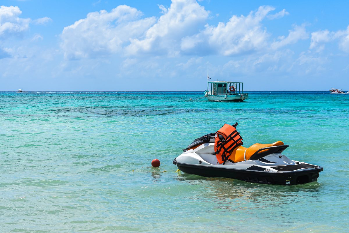 A WaveRunner® sits unoccupied on the water with a life jacket lying over the handles.