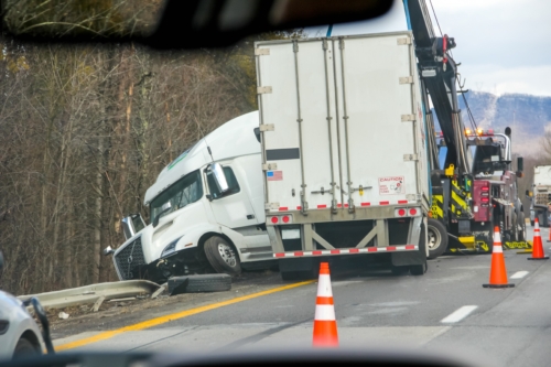 View of a semi-truck accident from inside a passing vehicle.