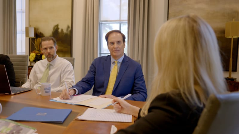 Attorneys Earle Long, Alan Colvin, and Cate E. Biggs sit at the Long & Long conference table discussing a case.